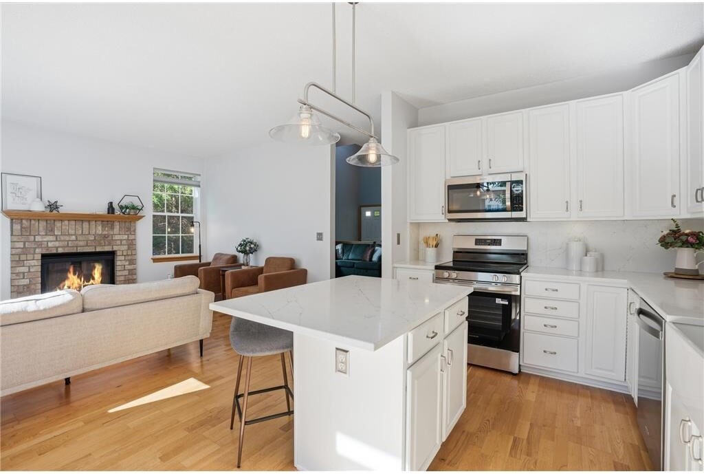 Kitchen with white cabinetry and brick fireplace